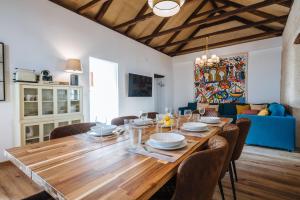 uma sala de jantar com uma mesa de madeira e cadeiras em Preciosa Casa Renovada Centro Histórico 11 personas em Sevilha