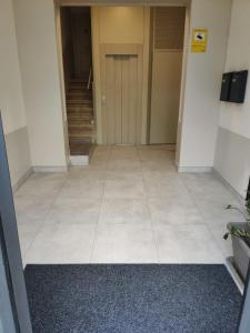 an empty hallway with a door and a tile floor at Diagonal Apartments in Barcelona