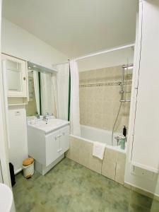 W łazience znajduje się biała wanna, umywalka i prysznic. w obiekcie Charmant appartement 3 pièces proche RER & Disney w mieście Montévrain