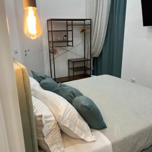 una camera da letto con un letto con cuscini verdi e bianchi di Napoli DownTown a Napoli