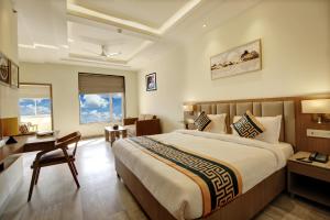 Habitación de hotel con cama grande y escritorio. en Airport Hotel Claytone en Nueva Delhi