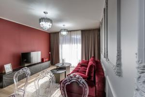 a living room with a red couch and a table at STUDIO 92- URBAN PLAZA in Braşov