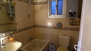 a bathroom with a sink and a toilet and a window at غرفة هادئه بمنزل قريب من المطار 701 in Cairo