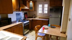 a kitchen with wooden cabinets and a table with chairs at غرفة هادئه بمنزل قريب من المطار 701 in Cairo