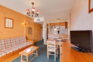 ein Wohnzimmer mit einem Sofa, einem TV und einem Tisch in der Unterkunft Cabourg - 33 - Studio bonne expo - 4 pers in Les Deux Alpes