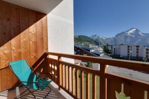 einen blauen Stuhl auf einem Balkon mit Aussicht in der Unterkunft Cabourg - 33 - Studio bonne expo - 4 pers in Les Deux Alpes