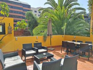 a patio with chairs and tables and an umbrella at Casa Consell Apartments in Barcelona