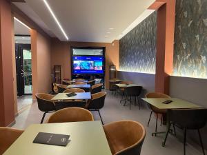 un restaurante con mesas y sillas y TV de pantalla plana en House Room Civico 56, en Crotone