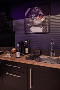 Una encimera de cocina con un fregadero y una foto de una mujer. en Espace évasions Loft love LOVE ROOM, en Toulouse