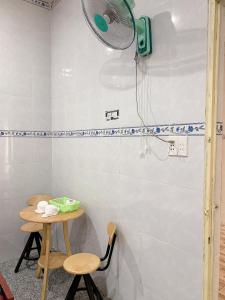ein Bad mit einer Dusche und einem Ventilator an der Wand in der Unterkunft Nhà Nghỉ Tấn Phát in Ấp Thanh Sơn (1)
