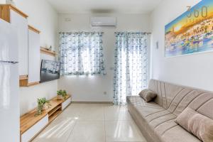 - un salon avec un canapé et une télévision dans l'établissement Beautiful 2BR Penthouse with Private Terrace & BBQ by 360 Estates, à San Pawl il-Baħar