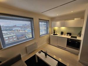 a kitchen with a large window and a living room at Manor Mills JCS Property in Leeds