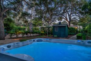 - une piscine dans une cour avec une cabane pour chiens dans l'établissement Lavish Montecito Home with Hot Tub, Patio and Gardens!, à Montecito