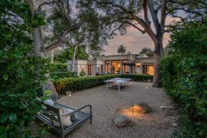 a house with a table and a bench in front of it at Lavish Montecito Home with Hot Tub, Patio and Gardens! in Montecito