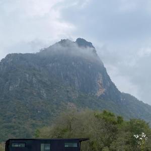 a mountain in the distance with a house in front of it at ริมบึงโฮมสเตย์ in Ban Phu Noi +7 photos
