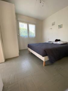 um quarto com uma cama com um gato sentado nela em An iodized vacation at home! em Frontignan