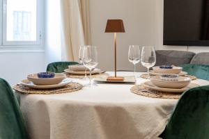 a table with plates and wine glasses on it at H11 [The King's Apartment] Ariston - Centro in Sanremo