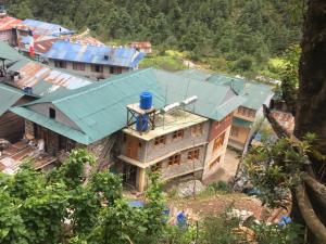 an overhead view of a house with a blue roof at Tribeni Lodge Restaurant And Bar in Phakding