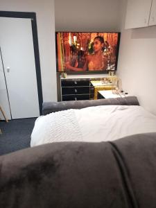 a bedroom with a bed and a flat screen tv at Beautiful En-suite Studio in Leeds -Lower Floor in Leeds