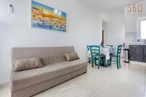 - un salon avec un canapé et une table dans l'établissement Beautiful 2BR Penthouse with Private Terrace & BBQ by 360 Estates, à San Pawl il-Baħar