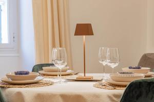 a table with plates and wine glasses on it at H11 [The King's Apartment] Ariston - Centro in Sanremo