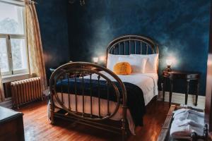 1 dormitorio con cama plegable en una habitación con paredes azules en Manoir Des Curiosités - Gite De La Tour, en La Pérade
