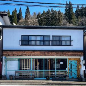 un edificio azul y blanco con balcón en omusubi guest house (JAPANESE　STYLE）, en Mamihara