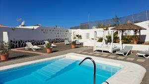 einen Pool mit Stühlen und einem Pavillon in der Unterkunft Inviting 1-bedroom house 'Esquina' Finca Vistamar in Salobre