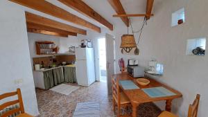 kuchnia z drewnianym stołem i lodówką w obiekcie Inviting 1-bed house 'Esquina' Finca Vistamar w mieście Salobre