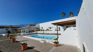 薩洛布雷的住宿－Inviting 1-bed house 'Esquina' Finca Vistamar，白色建筑前的游泳池