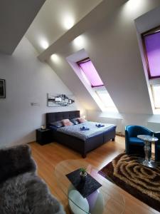 a bedroom with a bed and a couch and windows at LUX & Comfort in Košice