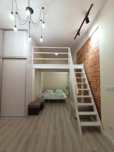 a room with a bunk bed and a brick wall at APARTAMANT DE LUX in Kluczbork