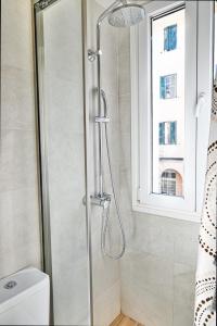 een douche in een badkamer met een toilet en een raam bij Old Town Apartment in Corfu-stad