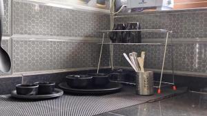 una cucina con pentole e padelle nere su uno scaffale di Euphoria Studioz a Mandrem