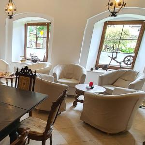 sala de estar con sillas blancas y mesa en Dworek Marmis, en Grudza