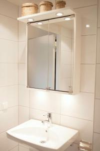 Baño blanco con lavabo y espejo en Charming one bed room apartment en Kottla