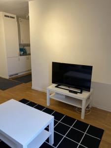 een woonkamer met een tv en een witte tafel bij Great 1 bedroom flat on Lidingo in Kottla