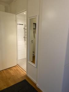 a bathroom with a mirror and a white wall at Great 1 bedroom flat on Lidingo in Kottla