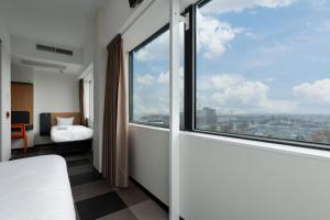 a bedroom with a bed and a large window at easyHotel Amsterdam Zaandam in Zaandam