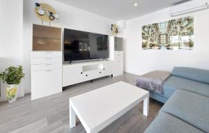 un soggiorno con un divano blu e una TV di Gorgeous Home In Riba-Roja De Turia a Riba-Roja De Túria