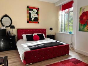 um quarto com uma cama grande e uma cabeceira vermelha em Exmoor Manor Guest House em Lynton