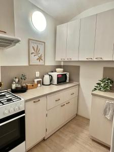 uma cozinha com armários brancos e um micro-ondas em Apartment Lea - Old Town em Bratislava