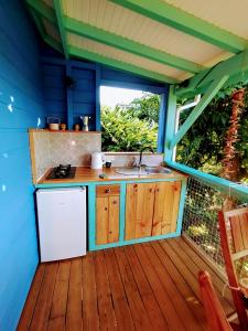 a kitchen with a white refrigerator and a sink on a deck at Kaz à Rosa in Petit-Bourg