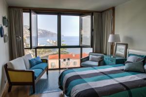 a hotel room with a bed and a large window at Monumental Apartment in Funchal