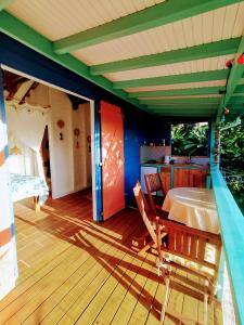 a house with a table and chairs on a deck at Kaz à Rosa in Petit-Bourg +3 photos