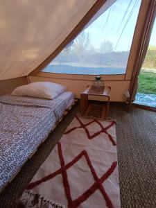 a bedroom with a bed and a large window at Du cote de Roussay in Roussay