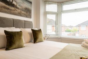 a bedroom with a white bed with two windows at Lovely 3 Bed Home in Ellesmere Port - With Parking - Sleeps 5 in Sutton