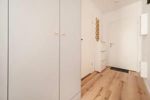 a room with white cabinets and a hardwood floor at Platon Modern Studio in Łódź