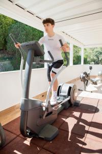 a man standing on a treadmill in a gym at Hotel Mediterraneo in Laigueglia