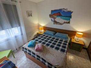1 dormitorio con 1 cama y una pintura en la pared en La Casa del Sol, Abades, en Abades